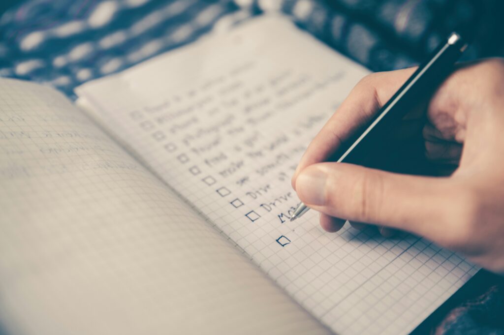 Photo of a hand and a check-list being written